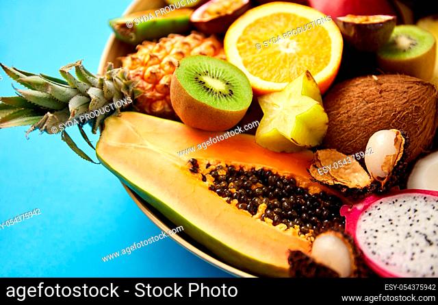 plate of exotic fruits on blue background
