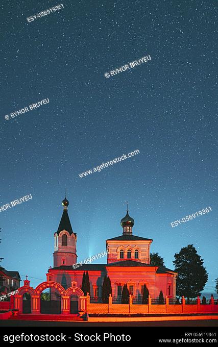 Korma Village, Dobrush District, Belarus. Comet Neowise C2020f3 In Night Starry Sky Above St. John The Korma Convent Church In Korma Village