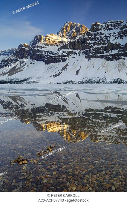 Sunset on Crowfoot Mountain and partially frozen Bow Lake along the Icefields Parkway, Banff National Park, Alberta, Canada