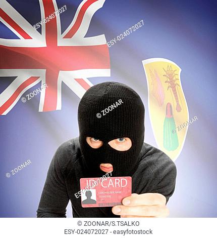 Hacker with flag on background holding ID card in hand - Turks and Caicos Islands