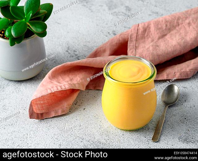 Yellow mango lassi on gray background. Indian mango yogurt drink with copy space left