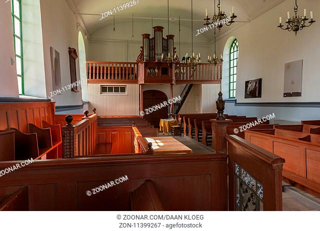 Feerwerd, The Netherlands - August 18, 2012: Interior with dark red church benches of the church of Feerwerd