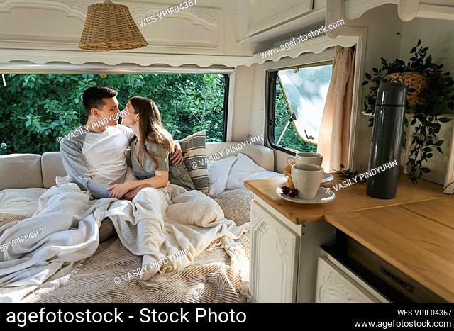 Young couple embracing each other on bed in motor home