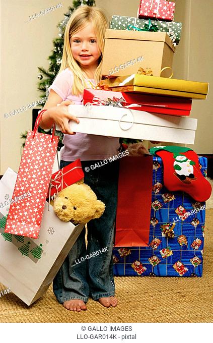 Portrait of a Young Girl Holding a Stack of Christmas Gifts  Cape Town, Western Cape Province, South Africa