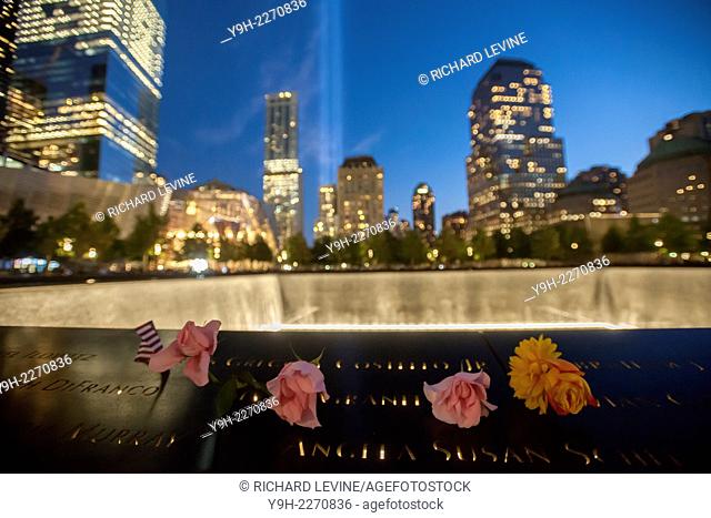 The Tribute in Light is seen behind the 9/11 Memorial waterfalls and reflecting pool in New York on September 11, 2014 for the13th anniversary of the September...