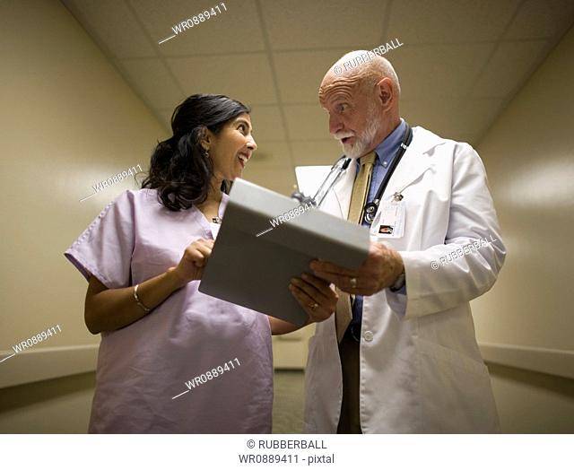 Low angle view of a female nurse talking to a male doctor