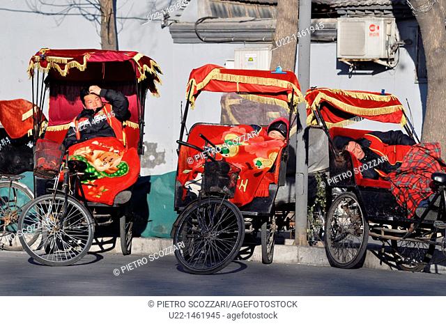Beijing (China): rickshaw drivers waiting for clients and taking a nap by the Bell Tower