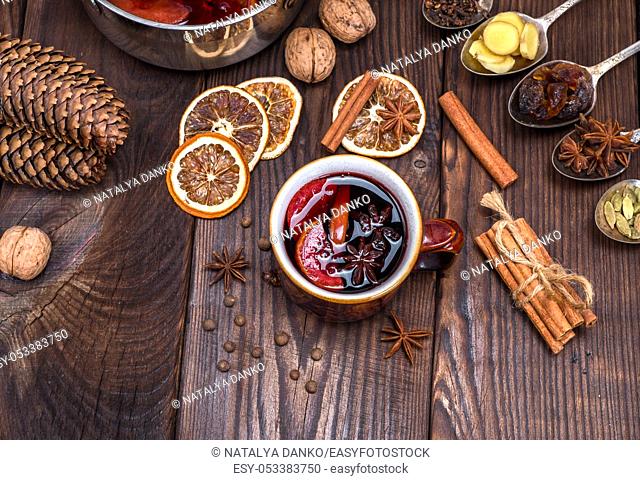 mulled wine in a brown cup and ingredients for making a drink, top view