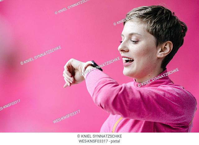 Woman in pink sportswear wearing smartwatch