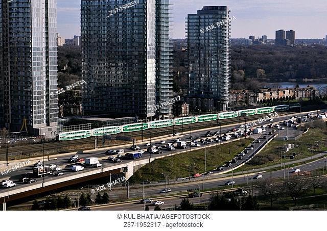 Green and white GO Transit Commuter Trains link Toronto City to suburbs, making it the Greater Toronto Area, GTA. Early morning traffic on the Gardiner...