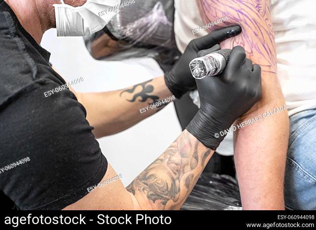 Salon tattoo. Close up of a Tattoo artist working. Tattoo artist make tattoo at the studio. High quality photography