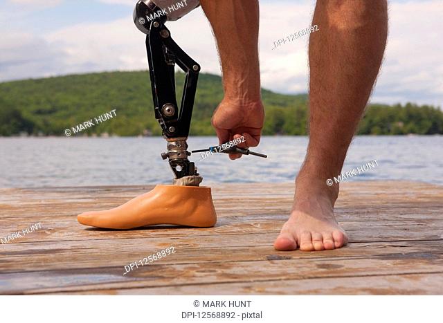Athlete adjusting his artificial leg on a dock