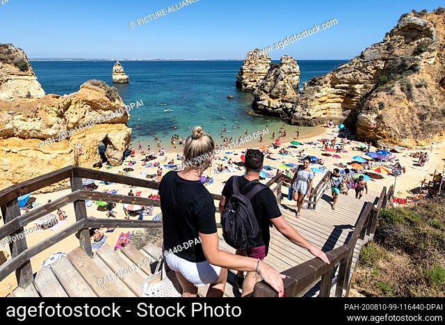 10 August 2020, Portugal, Lagos: Beach visitors go down stairs to the beach ""Praia do Camilo"". Photo: Matthias Balk/dpa. - Lagos/Portugal/Portugal