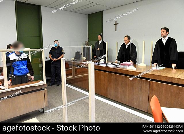 12 November 2020, Bavaria, Munich: A 24-year-old defendant (l) charged with attempted murder is standing before Judge Norbert Riedmann (r) in the courtroom of...