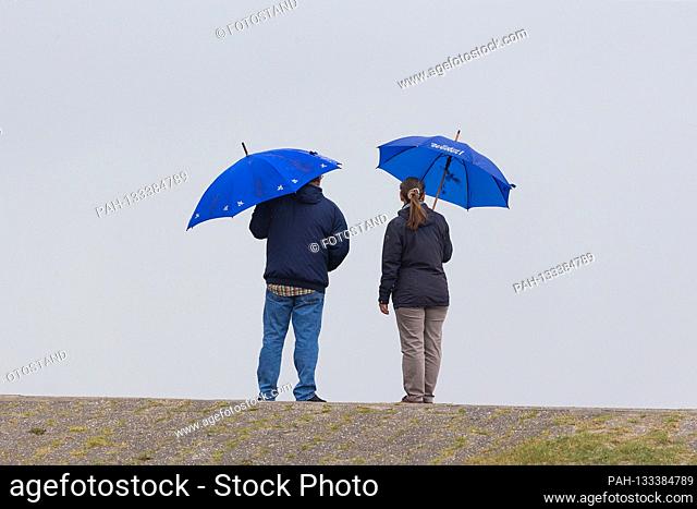 Harlesiel / Carolinensiel, Germany June 2020: Symbolic images - 2020 A man and a woman are standing on the dyke in Carolienensiel-Harlesiel when it rains