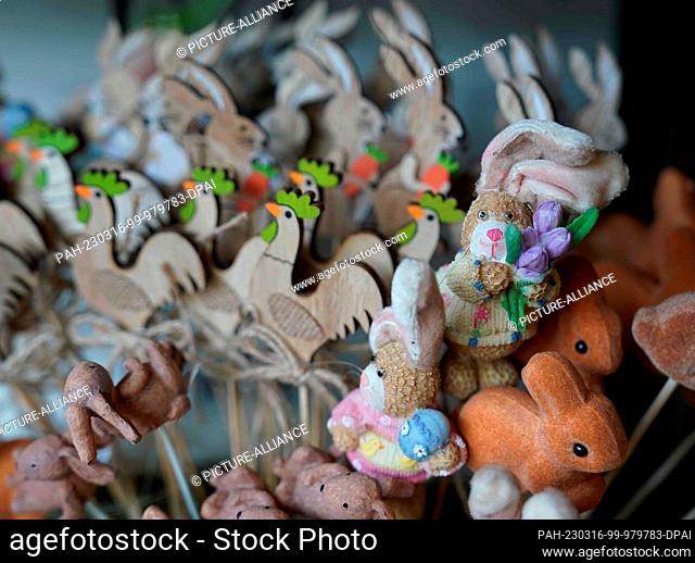 14 March 2023, Hamburg: Small decorative Easter bunnies and roosters stand on a shelf in a flower store. Photo: Marcus Brandt/dpa