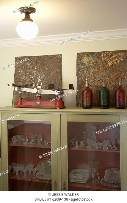 Scales Collection: Red cast iron scale on top of cabinet filled with Candlewick glassware.Antique ceiling tin panels, 3 glass spritzer bottles