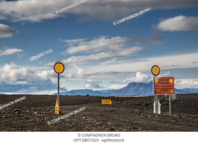 ROAD CLOSED SIGNS AT THE VOLCANO'S SITE, PLATEAU OF MODRUDALUR, TO THE RIGHT THE VOLCANO HERDUBREID AND TO THE LEFT A CLOUD FROM THE VOLCANO BARDABUNGA SPEWING...