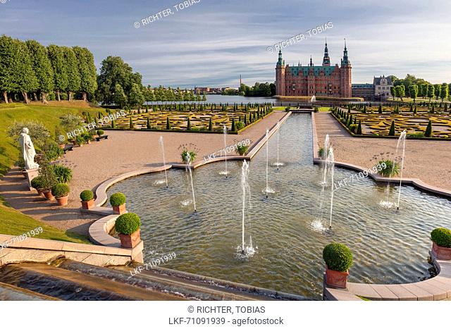 View arcoss the baroque gardens with fountain to the water castle Frederiksborg on a summer day, Hiller°d, Hovedstaden, Denmark