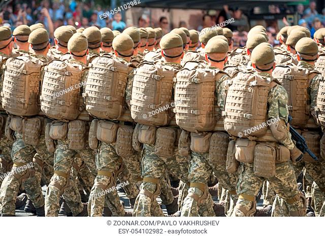 Army soldiers in camouflage marching on military parade