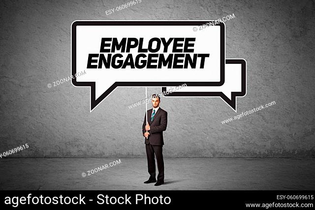 Young business person in casual holding road sign with EMPLOYEE ENGAGEMENT inscription, new business idea concept