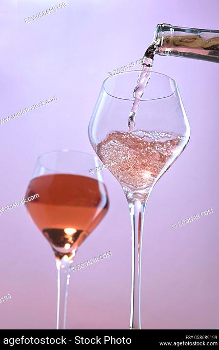 A concept studio image of pouring rose wine into a wine glass
