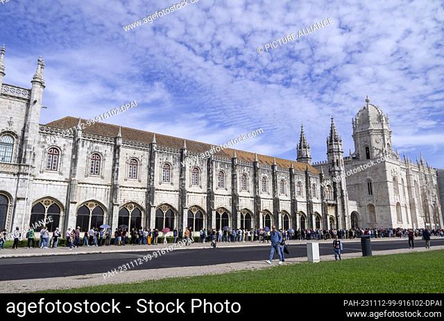 PRODUCTION - 26 October 2023, Portugal, Lissabon: Numerous tourists wait in a long queue in front of the ""Mosteiro dos Jeronimos"" monastery with the ""Santa...