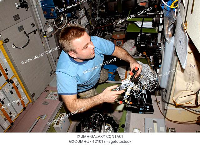 Russian cosmonaut Maxim Suraev, Expedition 22 flight engineer, works with GFI-1 Relaksatsiya (Relaxation) Earth Observation experiment hardware at a window in...