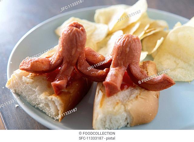 Octopus shaped hotdogs on buns with ketchup and potato crisps