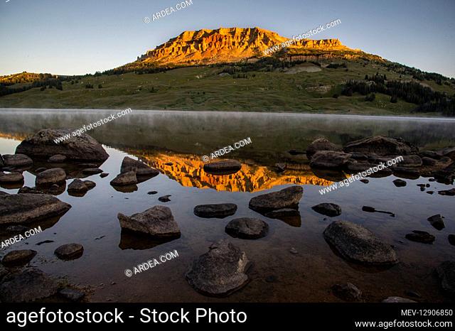 Beartooth Butte reflecting in Beartooth Lake shortly after sunrise. Wyoming. Summer