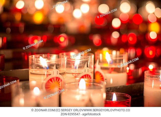 A lot of colorful candles at medieval altar, low key shallow focus image