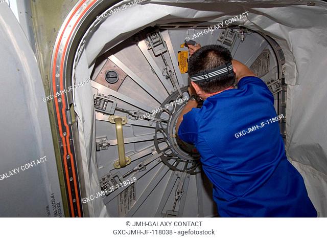 Japan Aerospace Exploration Agency astronaut Aki Hoshide, Expedition 32 flight engineer, prepares to open the hatch to the newly attached Japan Aerospace...