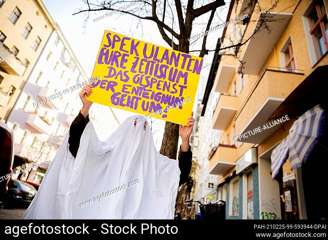 25 February 2021, Berlin: An activist in a ghost costume holds a protest sign near the organizing office of the people's petition ""Expropriate Deutsche Wohnen...