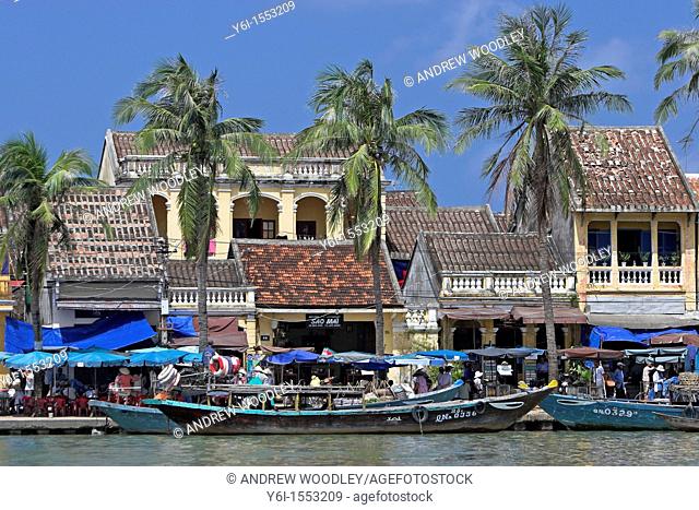 Boats palms old buildings Hoi An historic town riverfront mid Vietnam