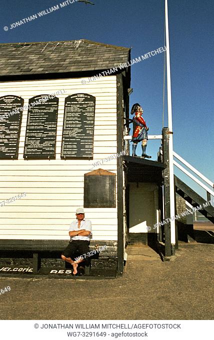 UK Broadstairs -- 09/2002 -- Man sits enjoying the sunny weather underneath the Old Lifeboat Station (signs list some of it's history) -- Picture © Atlas Photo...