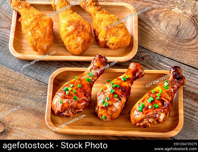 Breaded and grilled chicken drumsticks on rustic background