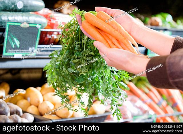 Young woman holding a bunch of carrots