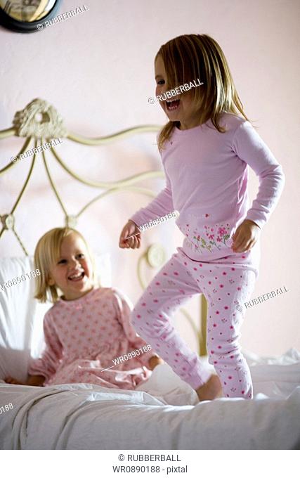 Two girls playing on the bed