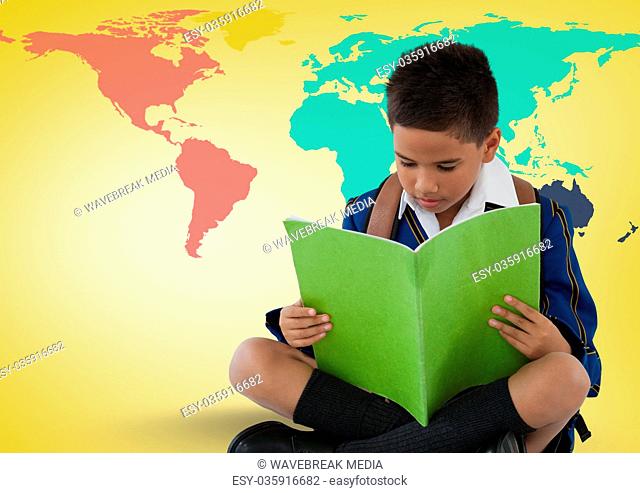 Schoolboy reading in front of colorful world map
