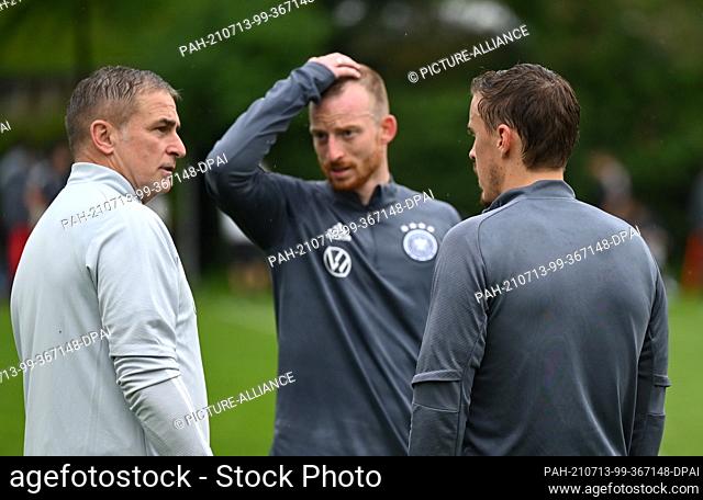 13 July 2021, Hessen, Frankfurt/Main: Stefan Kuntz (l-r), head coach of the Olympic soccer team, talks to players Maximilian Arnold and Max Kruse after final...