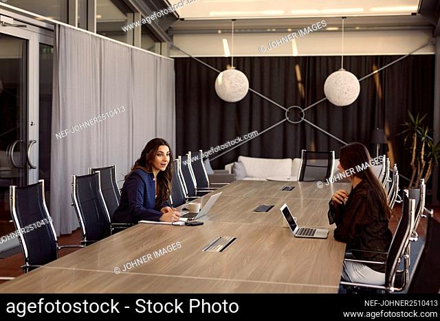 Female coworkers talking in boardroom
