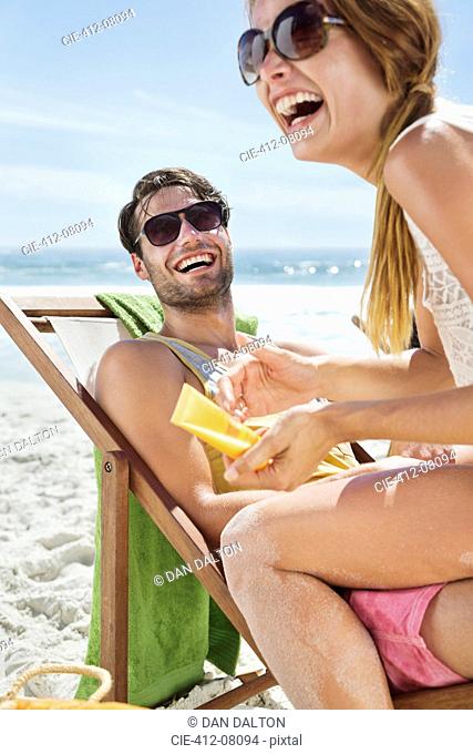 Happy couple with sunscreen at beach