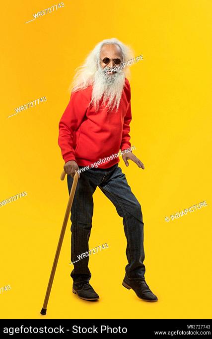 A PLAYFUL OLD MAN HAPPILY POSING IN FRONT OF CAMERA