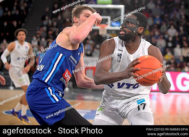 02 January 2022, Hamburg: Basketball Bundesliga, Hamburg Towers - ALBA Berlin, Matchday 15 at edeloptics.de Arena. Hamburg's Eddy Edigin (r) with face mask and...