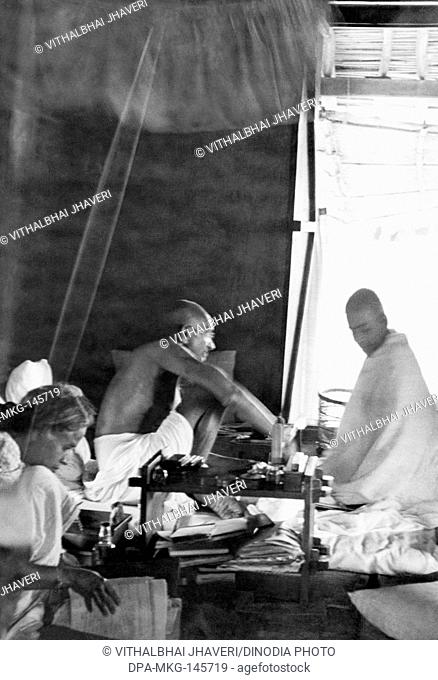 Mahatma Gandhi , working in the office hut at Sevagram Ashram , 1944 , Sushila Pai worker at the ashram office NO MR