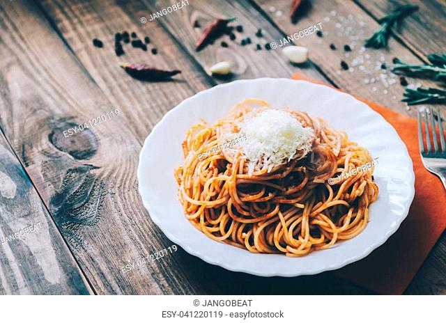 Pasta with tomato sauce and rosemary on table
