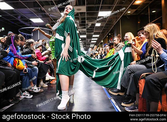 16 January 2023, Berlin: An activist stands on the catwalk at a performance disguised as an Adidas show during Berlin Fashion Week