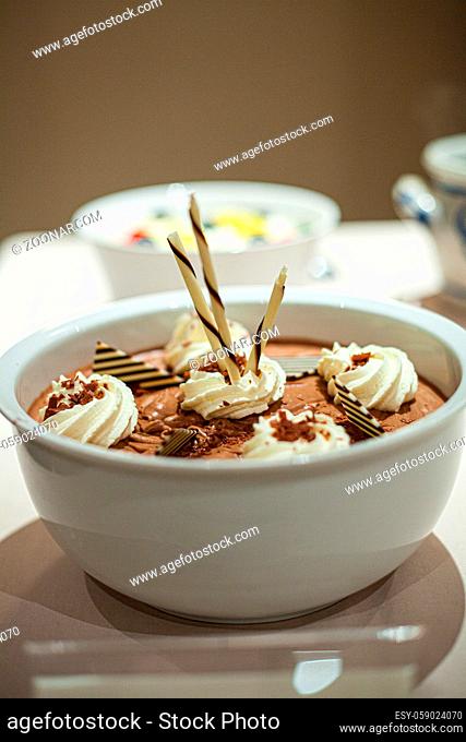 chocolate mousse in a white Cup decorated with chocolate and whipped cream. High quality photo
