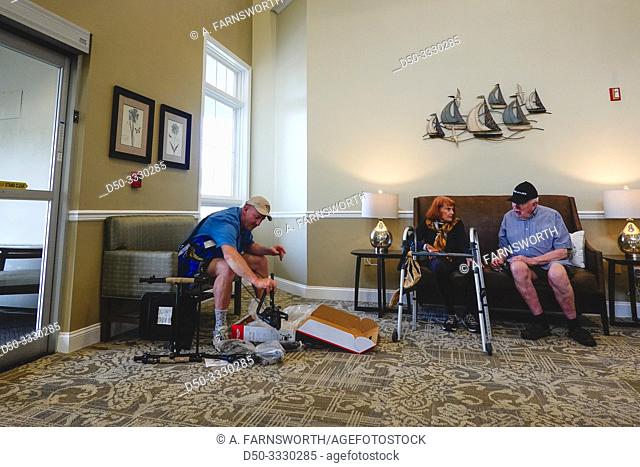 Solomons Island, Maryland, USA A son assembles a walker for his senior parents in a nursing home