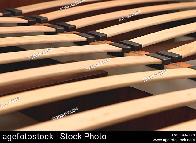 Close-up wooden elements of an arthopedic base of a double bed. Interior structure of furniture